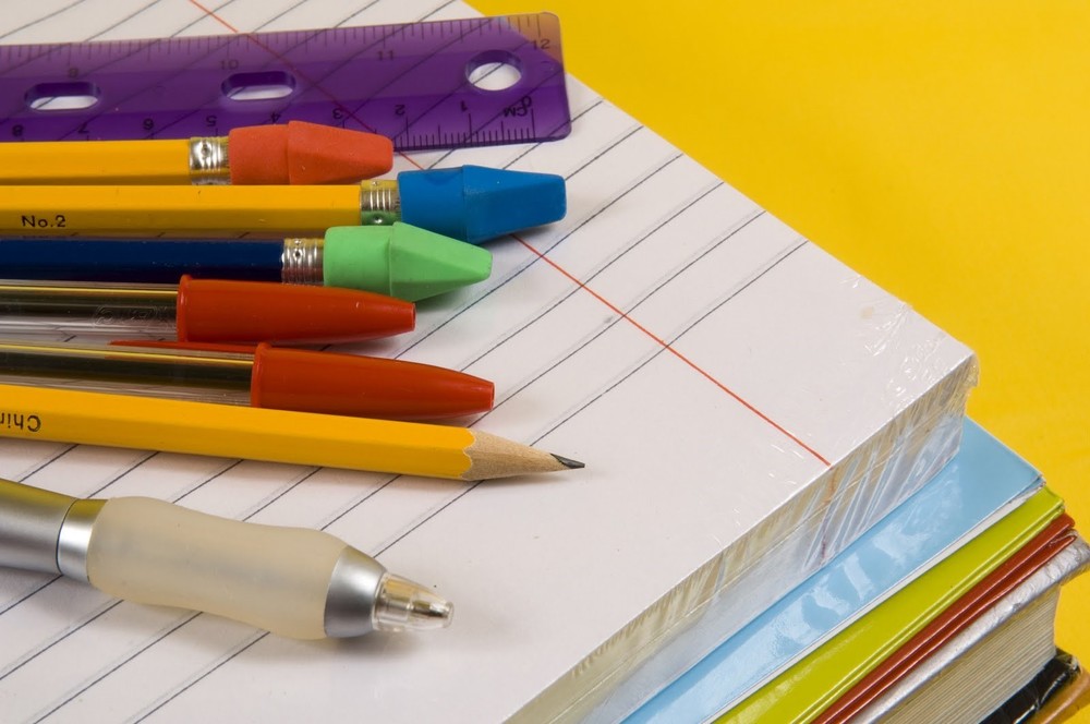 Pens, Pencils, and a Ruler on a Stack of Paper