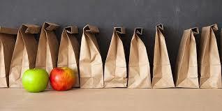 Brown lunch sacks behind two apples.